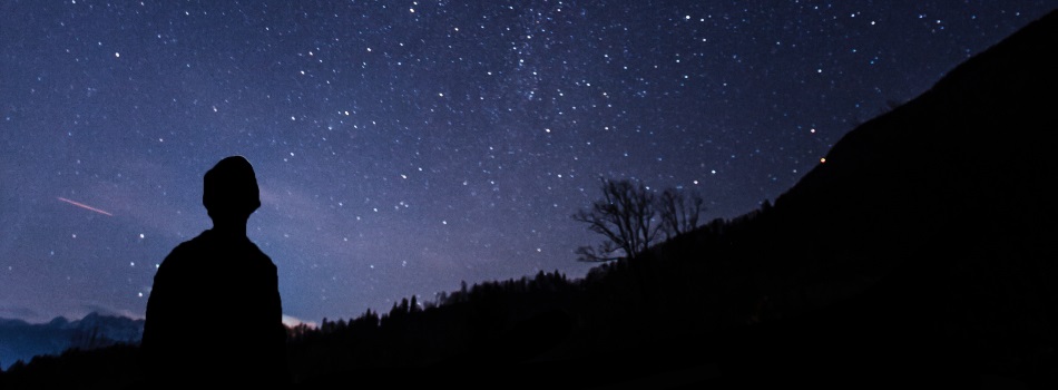 Long-exposure view of the stars, creating an arc in the sky.